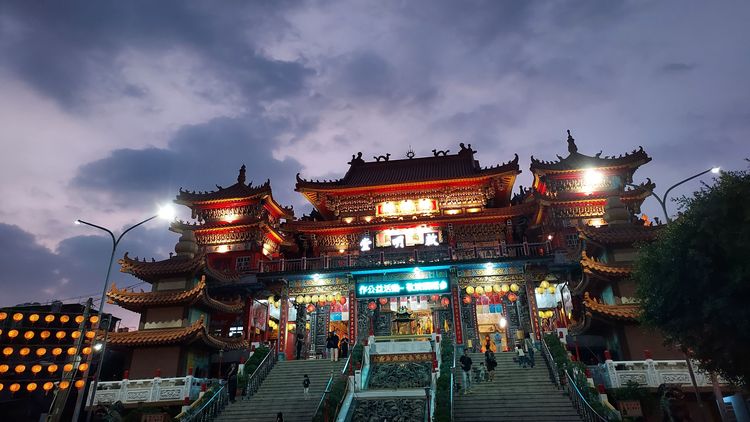 A Buddhist temple with a wide staircase and bright lighting. 