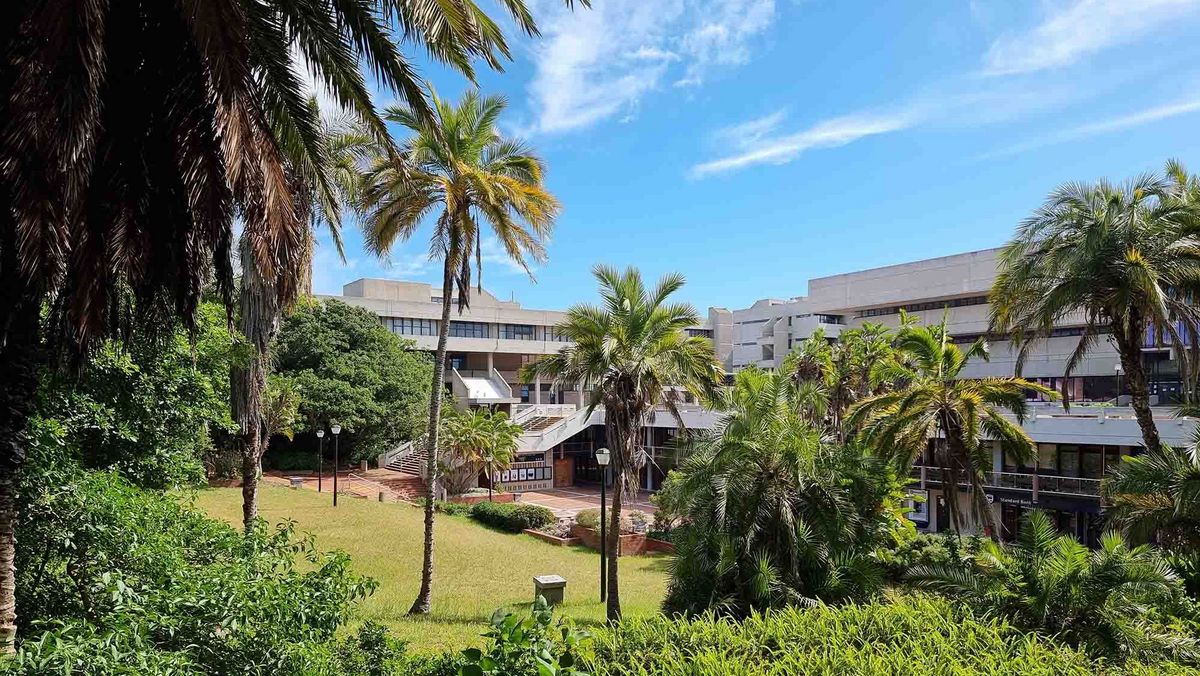 Der Campus der Nelson Mandela University mit modernen Gebäuden und üppiger Vegetation.