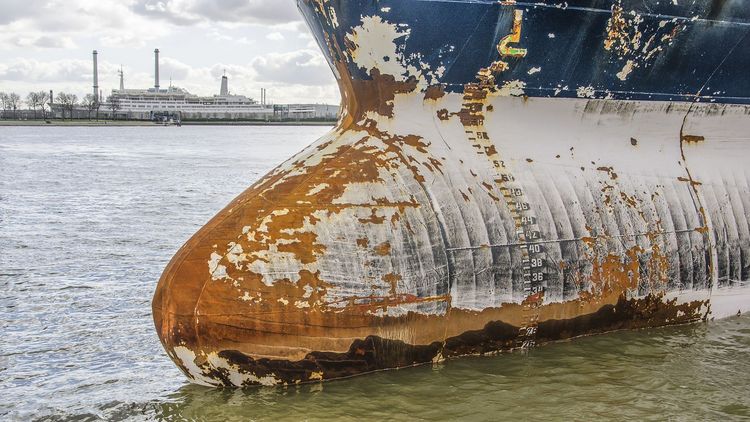 Bow of a ship with numerous rust stains.
