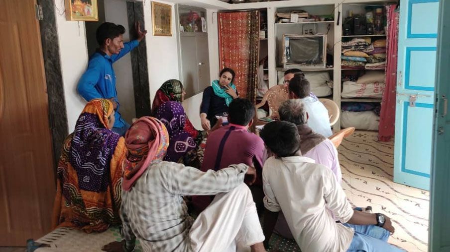 Eine Gruppe von Menschen in traditioneller Kleidung sitzt in einem Raum zusammen.