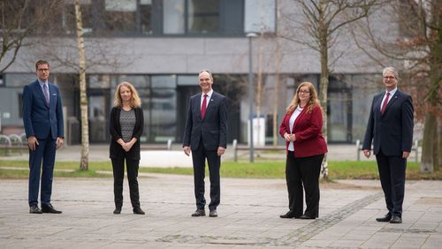 Die fünf Personen stehen mit Abstand vor dem Gebäude A5 der Universität