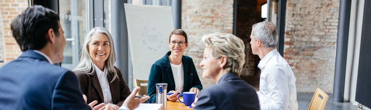 Mitarbeiter im Ausland an einem Tisch sitzend