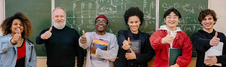 Group of teachers in front of a blackboard in a classroom.