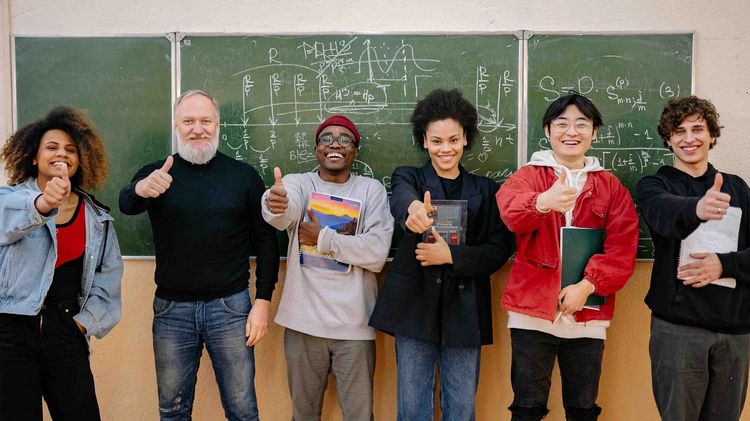 Group of teachers in front of a blackboard in a classroom.