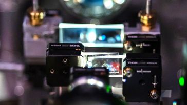 The picture shows a complicated test setup for an optical experiment. The laser light passes through two arrays of two wedge-shaped glass plates positioned closely behind each other.