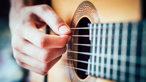 Großaufnahme von Gitarren-Griffbrett und linker Hand.