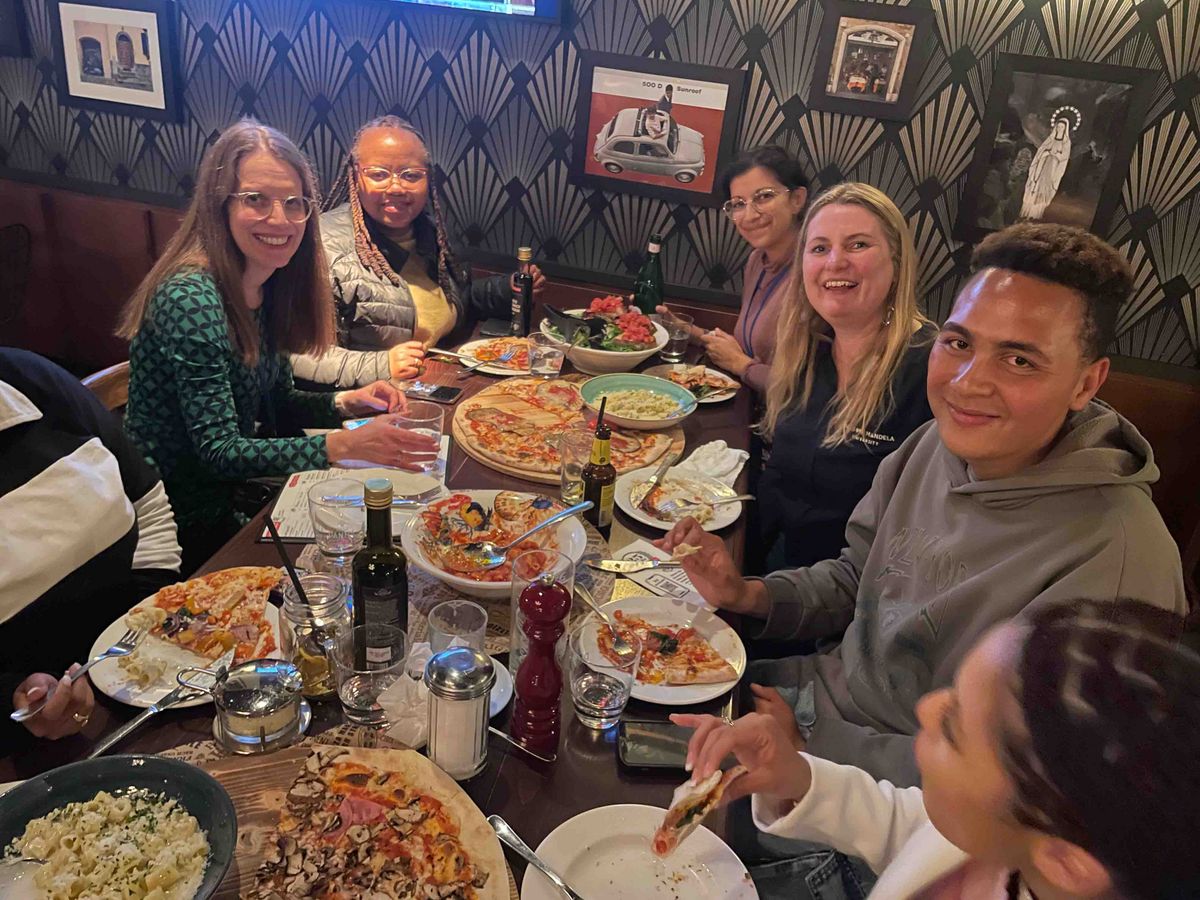  A group of participants at the DAAD Winter School having pizza in a restaurant.