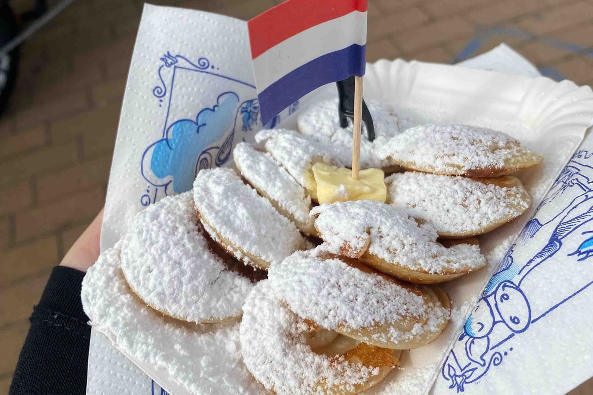 Dutch pastries called “poffertjes”, which resemble small round pancakes, served with butter, a miniature Dutch flag and plenty of icing sugar.