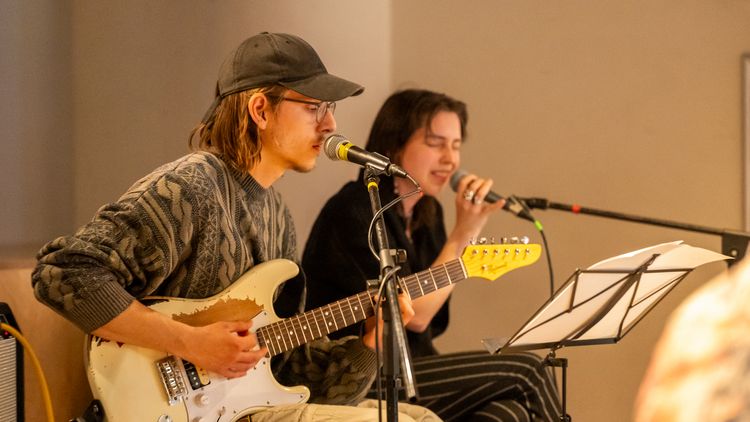 A guitarist and a singer perform live on stage.