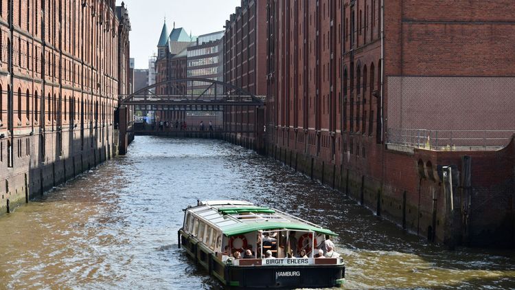 A view of the Speicherstadt warehouse district and a sightseeing boat in the foreground. 