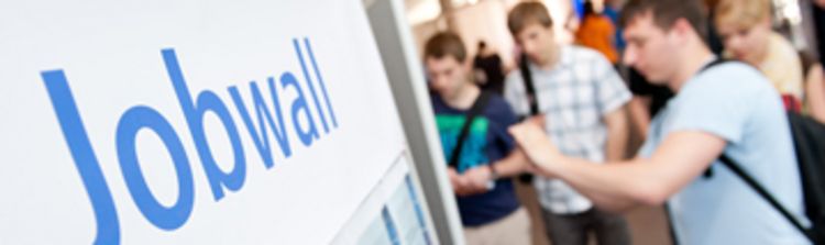 Studierende und Interessierte interagieren mit Informationstafeln.