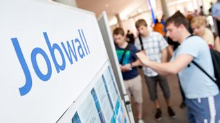 Students and interested parties interact with information boards.