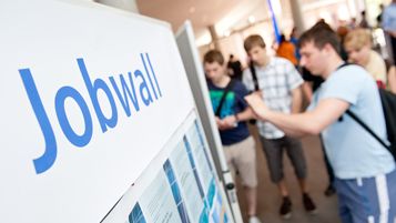 Studierende und Interessierte interagieren mit Informationstafeln.