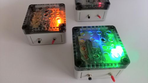 Close-up of the sensor nodes: Square boxes with two switches on the side, one lights up red, the other green.