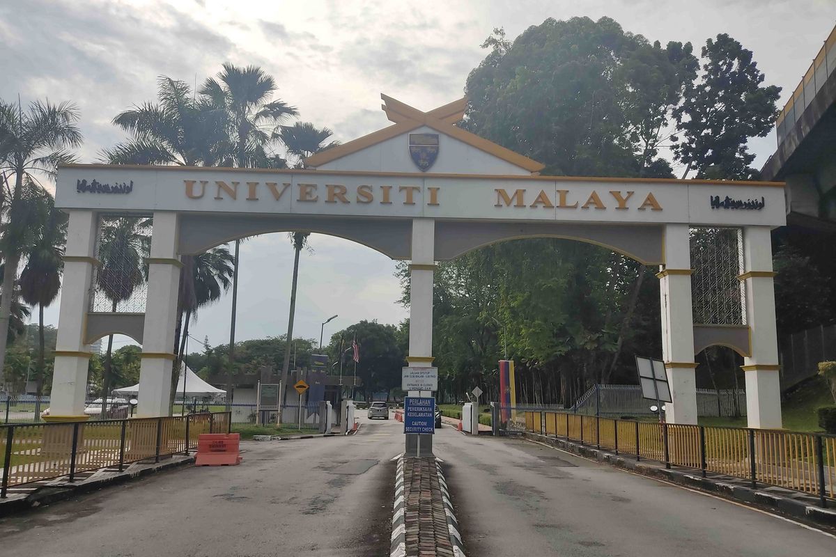 Das Haupteingangstor der University of Malaya in Kuala Lumpur, Malaysia. Über dem Torbogen steht der Schriftzug "Universiti Malaya" in gelber Schrift.