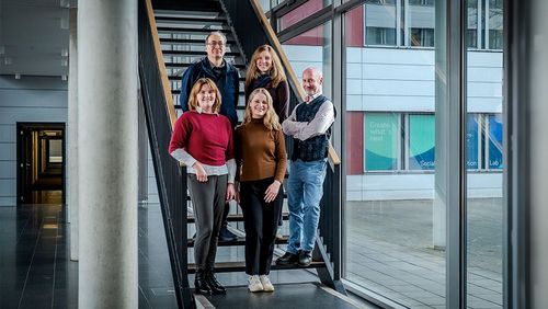Fünf Menschen stehen auf einer Treppe.