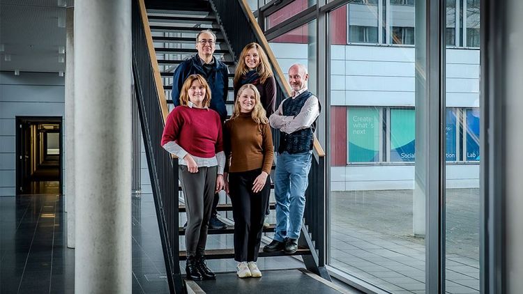 Fünf Menschen stehen auf einer Treppe.
