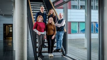 Fünf Menschen stehen auf einer Treppe.