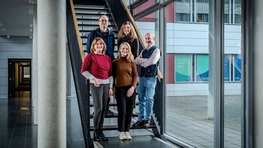Fünf Menschen stehen auf einer Treppe.