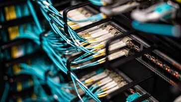 Großaufnahme von zahlreichen Kabeln und Steckern, die zu einem Großrechner gehören. 