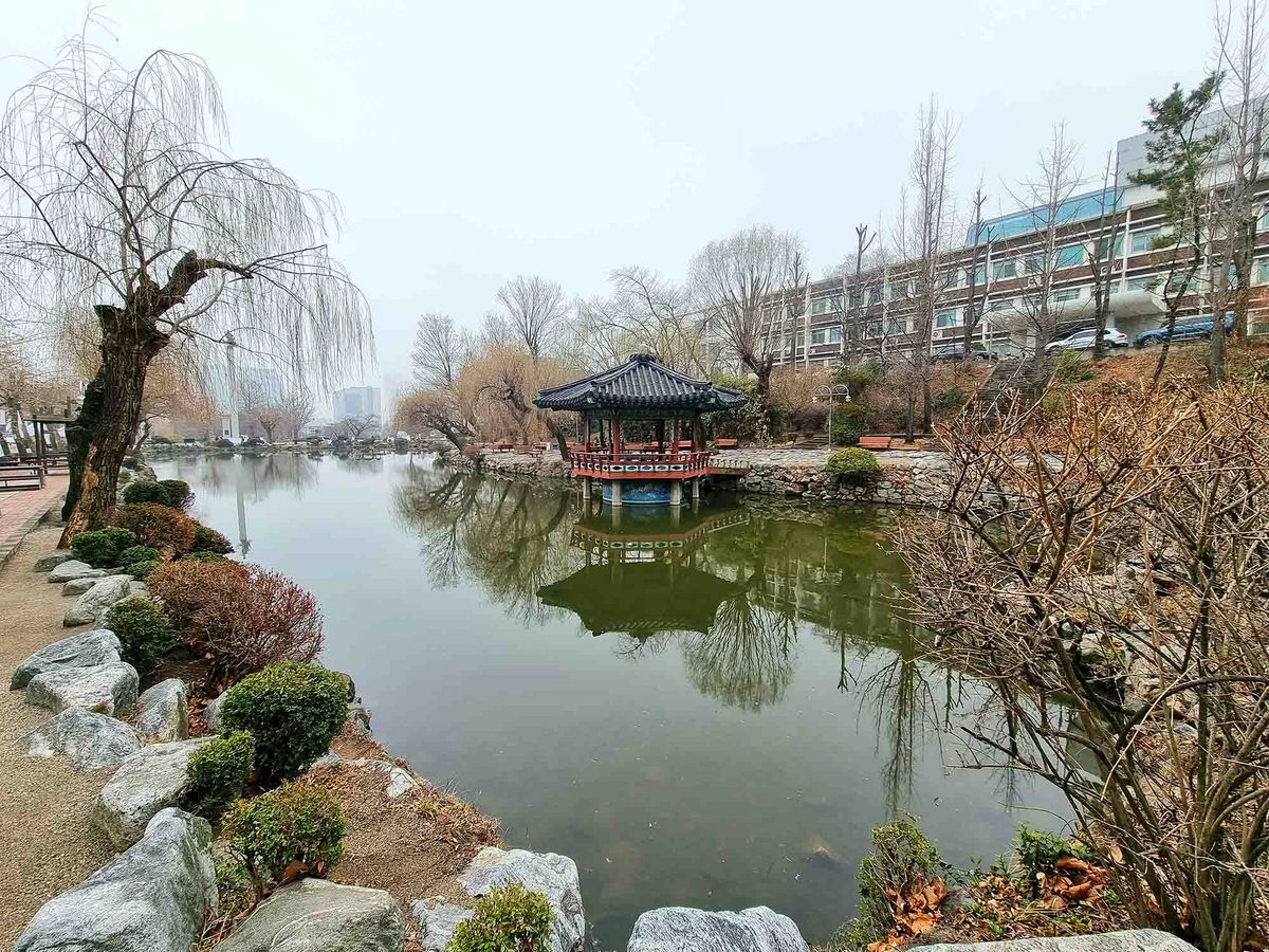 A pond with a traditional pavilion on the campus of Inha University.