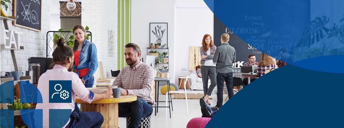 Many people sit and stand in a co-working office and talk to each other.