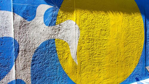 Wandbild zeigt weiße Taube auf blauem Grund, daneben ein gelber Kreis.