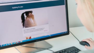 Eine Person vor einem Computer.