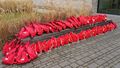 42 red backpacks lie on top of andin front of a bench near the experimental lecture hall in Wechloy.