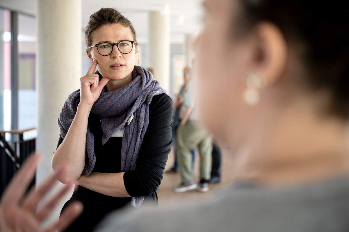 Das Foto zeigt eine interesiert zuhörende, stehende Personen in der Gruppenarbeitsphase beim ersten Sustainability Sounding Boards des universitären Klimaschutzmanagements.