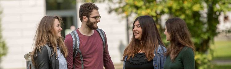 Vier junge Erwachsene stehen vor dem SSC und unterhalten sich.