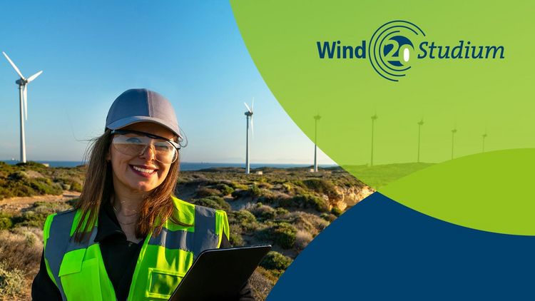 20 Jahre Jubileum Windstudium Eine Frau in Warnweste steht vor mehreren Windrädern und lächelt in die Kamera.