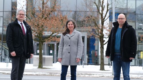 three persons in front of the university