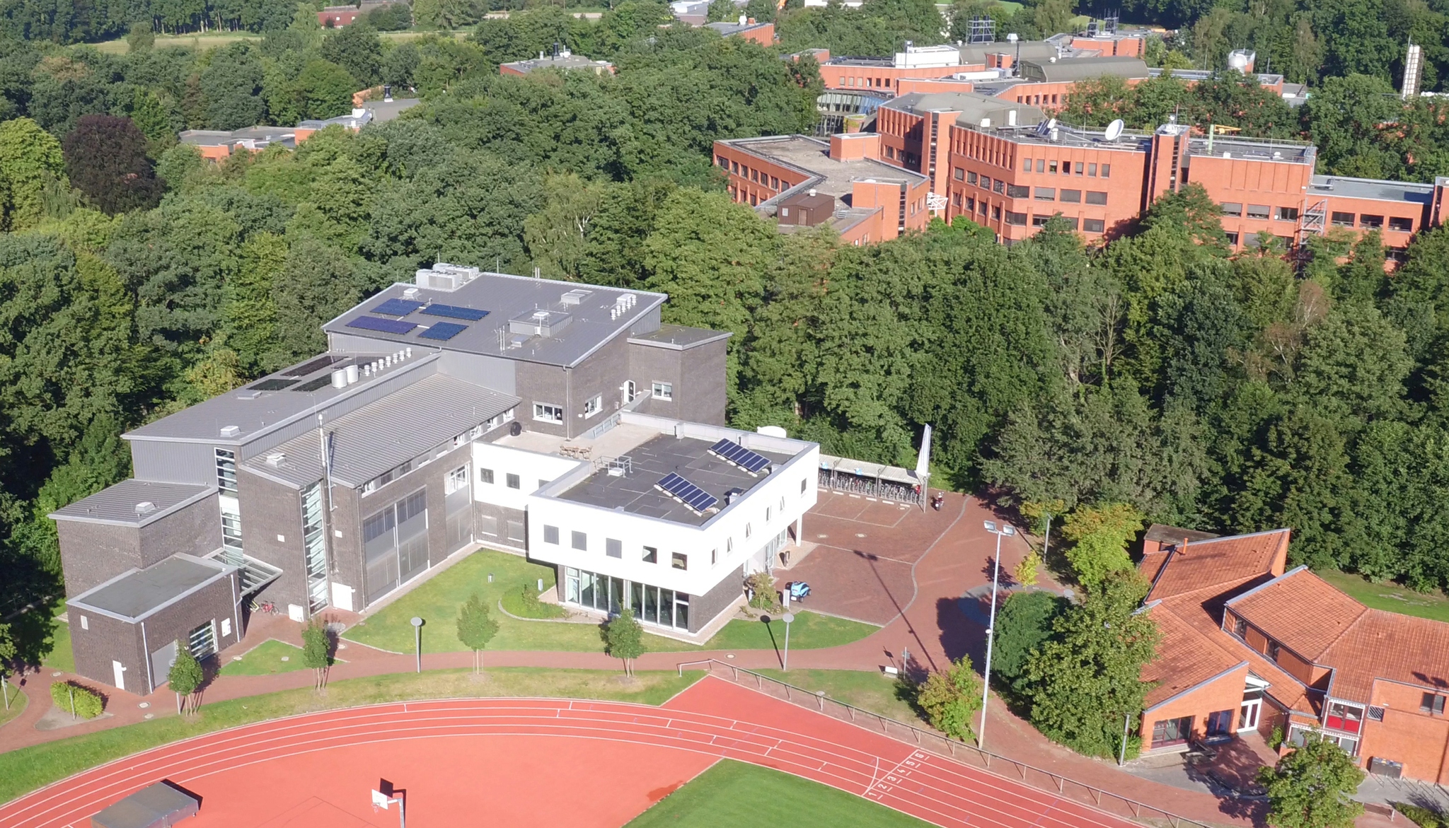 Luftbild des Gebäudes von schräg oben. Im Hintergrund sind Bäume und das Wechloyer Hauptgebäude zu erkennen.