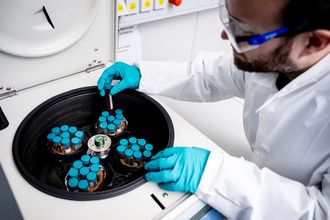 Forscher mit Schutzbrille an Zentrifuge
