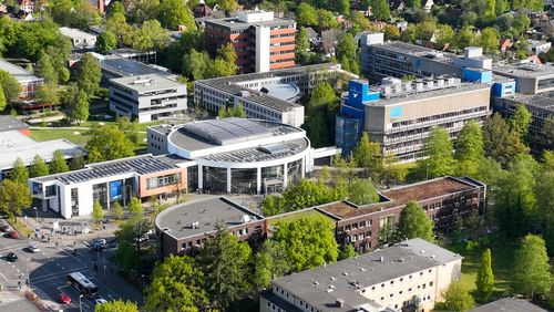 Das Bild zeigt eine Luftaufnahme des Campus Haarentor von oben bei schönem Wetter. Zu erkennen sind unter anderem das Hörsaalgebäude, das Studierenden Service Center und der Trakt A 1-4.